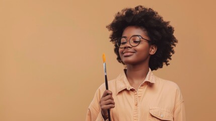 Artistic Flair: Artistic African American teen holding a paintbrush, isolated on a simple beige background. With a playful smirk and a creative glow, styled as an inspirational creative portrait. - Powered by Adobe