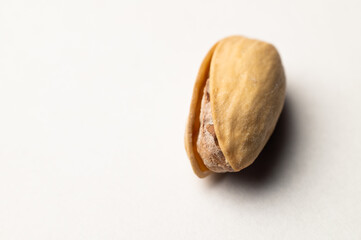 One pistachio nut on a white background, close-up