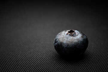 One blueberry black background. Very detailed macro shoot with copy space