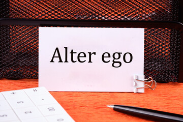 Alter ego It means the Second I on a clean white business card next to a calculator, a pen on an...