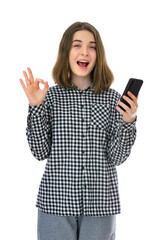 Portrait of pretty eighteen years old womantake selfie and make OK signs, isolated on white background. Studio shot of young woomen holding cell phone and having video call. - obrazy, fototapety, plakaty