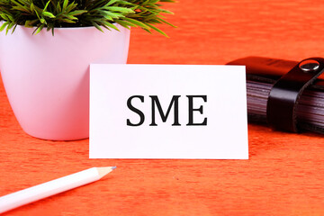SME (or small and medium enterprises) symbol it is written on a white business card next to a...