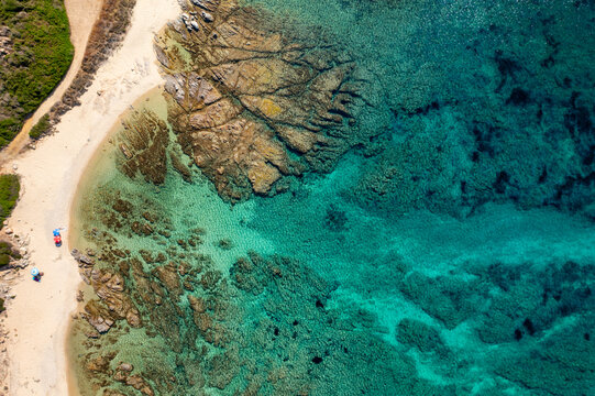Wild beach with sun umbrellas aerial drone top view