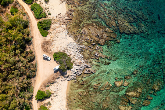 Camper vans on a wild beach aerial drone top view in Sardinia