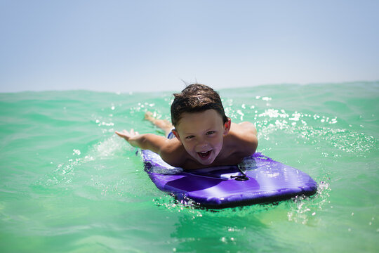Cheerful boy body surfing on a boogie board