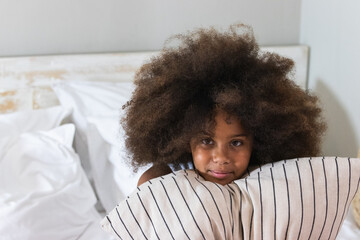Sleeping. Dreams. Woman portrait. Afro American girl in pajama is hugging a pillow in bed
