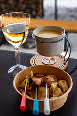 Savor alpine indulgence with fine wine and a fondue set, against the backdrop of a snowy mountain retreat.