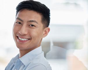 Asian man, portrait and business with smile for career ambition, entrepreneur or creative mindset at modern office. Face of young businessman leaning on glass wall in confidence for job or reflection