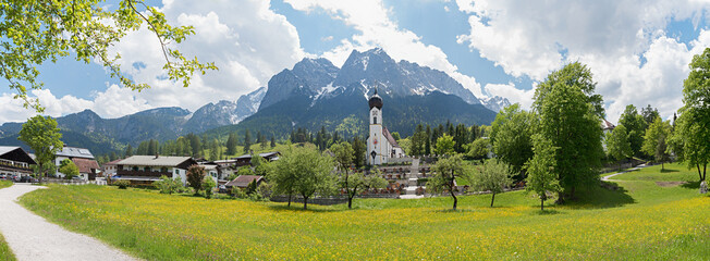 Landscape panorama of village church and cemetery Obergrainau, Wetterstein Mountains in spring - 793669293