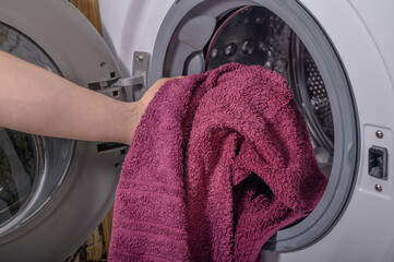 Wkładać brudny ręcznik do pralki z bliska - obrazy, fototapety, plakaty