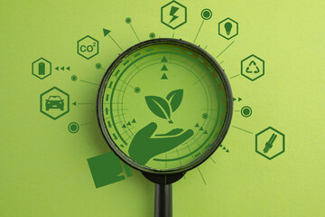 Hand Holding Green Leaf Connected to Energy Icons Through Magnifying Glass concept for Eco-friendly, Sustainable Future,Environmental Conservation Strategy,Innovation for a Cleaner Planet. - obrazy, fototapety, plakaty