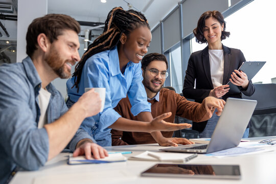 Group of diverse businesspeople using laptop while working together