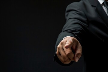  a businessman in a suit pointing with his finger on a black background