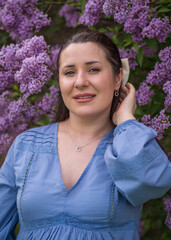 Portrait of a cute, happy girl. pregnant woman near lilac. Close-up. Pregnancy. Waiting for the baby.