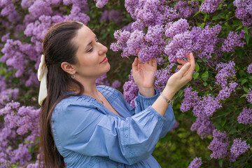 Portrait of a cute, happy girl. pregnant woman near lilac. Close-up. Pregnancy. Waiting for the bab - obrazy, fototapety, plakaty