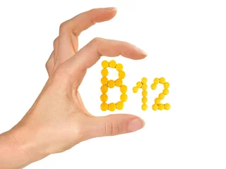 Fotobehang Vitamin B Pills isolated - B12 on white background with Woman Hand © ExQuisine