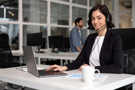 Happy smiling female customer support phone operator at workplace
