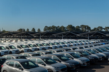 Centro de distribuição de carros novos em estacionamento. Muitos veículos aguardando venda ou...