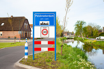 Place name sign of the small village of Polsbroekerdam, municipality of Lopik in the western part of The Netherlands. Under the sign is indicated that it is a zone with a speed limit of 30.