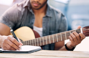 Man, guitar and writing in studio for music with notebook, natural talent and planning lyrics for song. Musician, string instrument and creative idea for chorus in home with composing for career