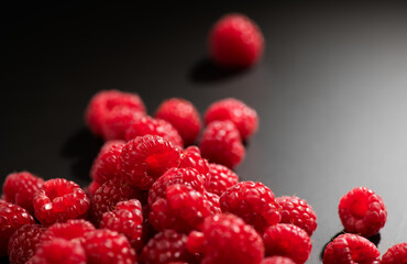 Raspberry fresh berries closeup, ripe fresh organic Raspberries over black background, macro shot. Harvest concept