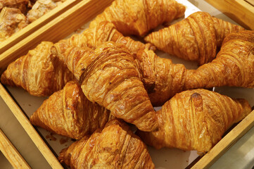 Pile of delectable freshly baked croissant pastries for sale in the bakery