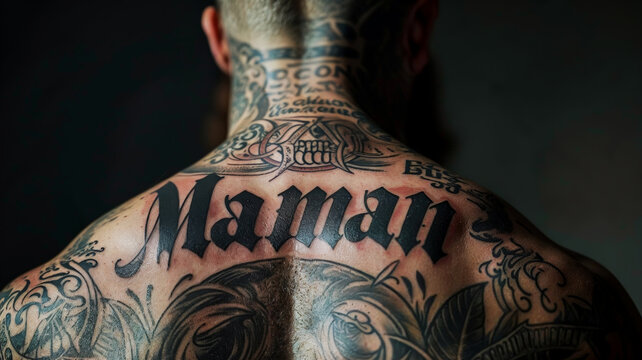 un homme costaud avec un tatouage "MAMAN" sur le dos et plein d'autres tatouages