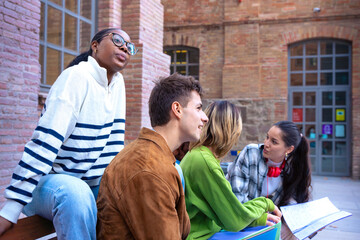  Smiling multiethnic students sitting reviewing class notes. University Life Concept.