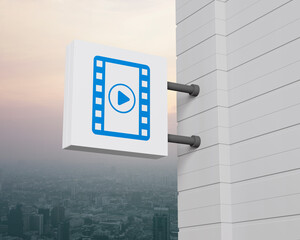 Play button with movie icon on hanging white square signboard over city tower and skyscraper at sunset sky, vintage style, Business cinema online concept, 3D rendering
