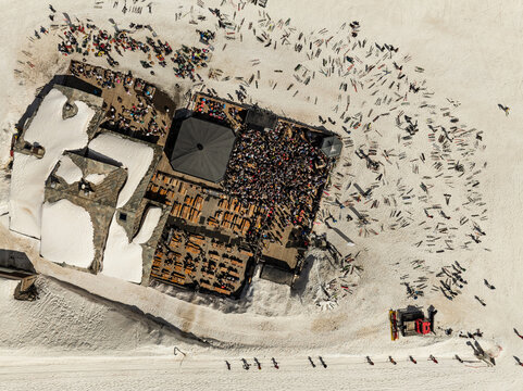 People dancing in a mountain bar in the ski resort of Les 2 Alpes, France. Aerial drone view of people enjoying apres-ski. Apres ski in a mountain chalet bar. les deux alpes. Apres ski in alps.
