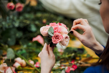 A lady holding a bouquet of pink Hybrid tea roses in her hands