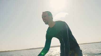 Portrait of a wakeboarder who has just wakeboarded. Portrait of a young guy in the backlight.