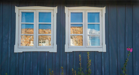 windows with white frame on blue facade and flowers of a typical scandinavian house - 793728497