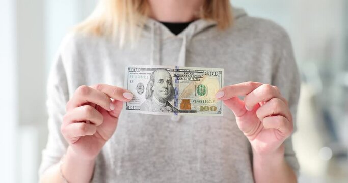 Closeup of a woman holding a 100 dollar bill