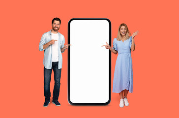 Man and woman presenting a large smartphone - obrazy, fototapety, plakaty