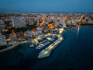 Puerto deportivo al atardecer con las luces de la ciudad