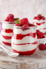 Vanilla white chocolate mousse, trifle, panna cotta or parfait with raspberry sauce in a glass jar. Sweet summer dieting dessert.