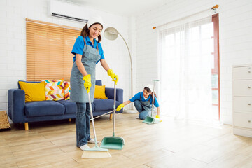 Two Asian young professional cleaning service women worker team working in the house. Girls...