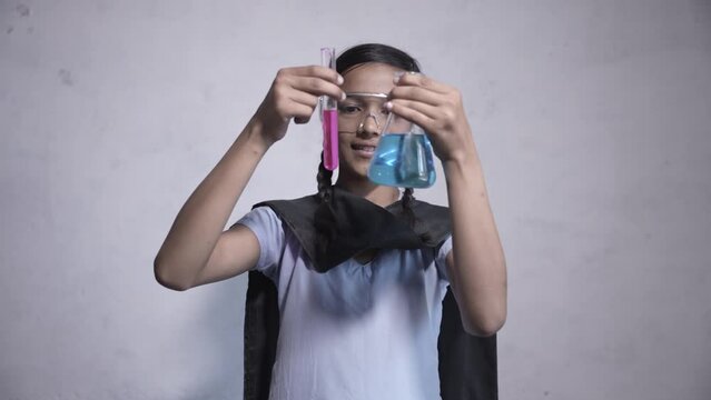 Rural indian schoolgirl student working in science chemistry lab, Education isolated against white background. Testbed and beaker chemical experiment