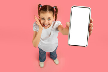 Cheerful girl showing phone with blank screen