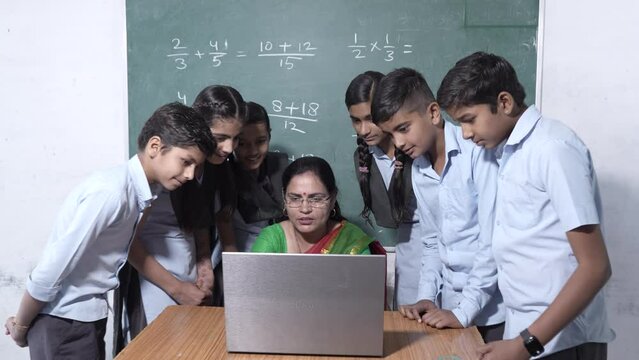 Indian female teacher and students using laptop during computer class at school. Technology web Education. Digital India.