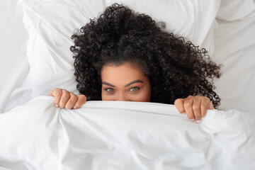Woman Peeking Out From Under a Blanket