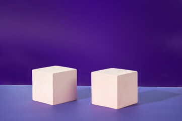 Two white cement cubic display on a purple background. Mockup for the demonstration of cosmetic products