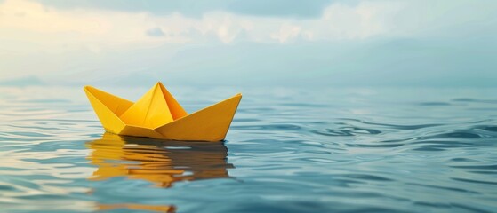 A vibrant yellow origami boat floats peacefully on a calm blue water surface, reflecting its bright color.