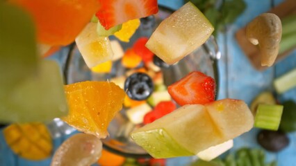 Falling Pieces of Fruits and Vegetables into Blender.