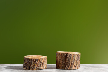 Two wooden round saw cuts on a green gradient background. Natural podiums for advertising cosmetic products. Nature concept.