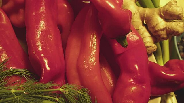 Close up of red bell peppers. sweet peppers and fresh green parsley leaves. Kitchen interior. Bell peppers are wet with droplets of water. Indoor studio shot. . High quality 4k footage