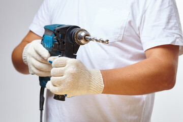 Man holding drilling tools in whtie gloves