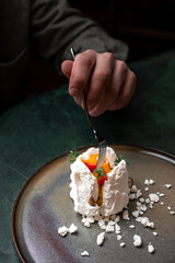 A tantalizing pavlova with vibrant fruit topping, nestled on a rustic plate for a perfect culinary...