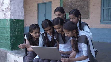 Group of Rural indian schoolgirls using laptop, Learn computer technology at elementary school. Smart Kids, Knowledge, Digital India. - Powered by Adobe